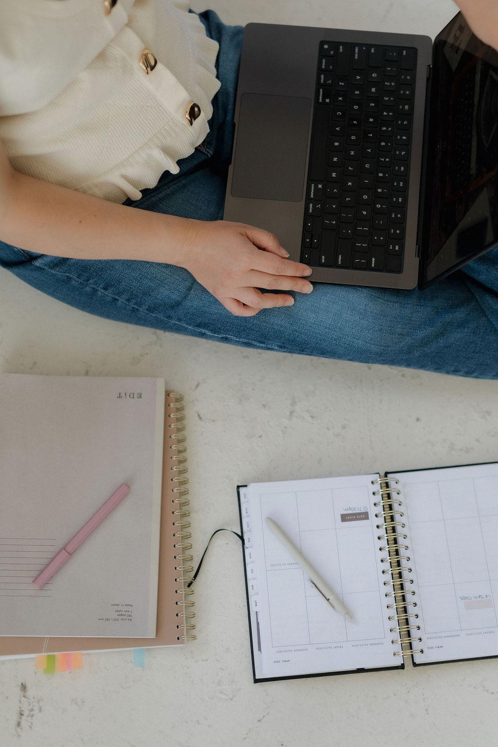 A laptop and weekly planner on a desk